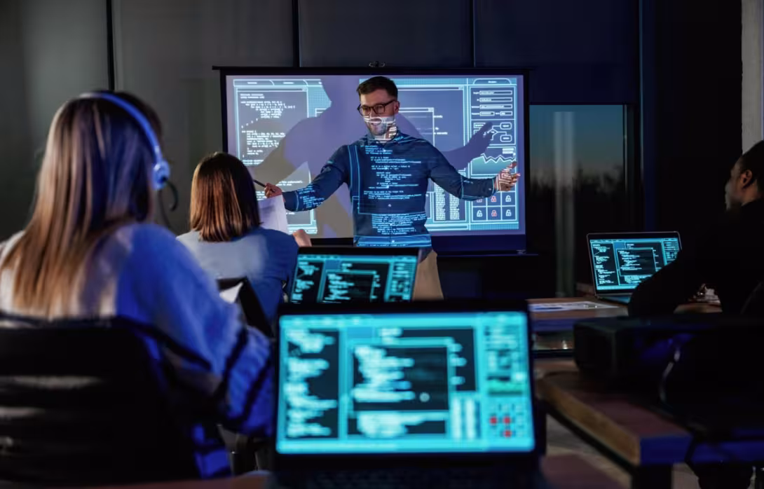 A trainer leads an interactive cybersecurity workshop with professionals coding in real time. The session emphasizes practical learning and modern digital defense strategies.